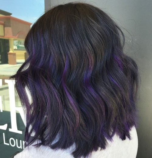 Dark brown base with purple peekaboo highlights, wavy shoulder-length hair, subtle hidden color beneath outer layers