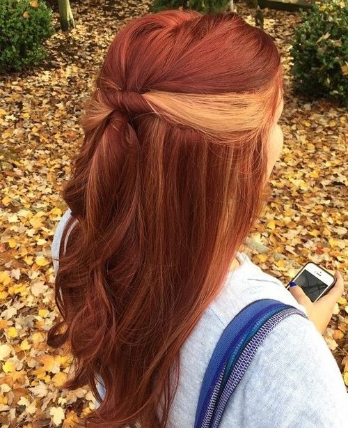 Long wavy red hair with blonde peekaboo highlights hidden beneath top layers, soft texture and natural fall tones