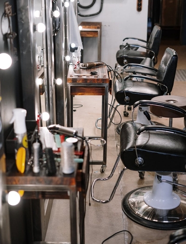 Modern salon with styling chairs mirrors and cart holding hair dye tools for peekaboo coloring