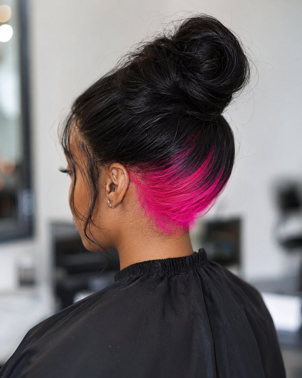 Black high bun revealing a hot-pink underlayer across the nape
