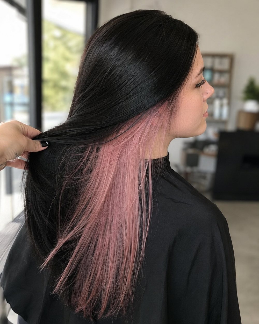 Long black hair swept aside to reveal a hidden pastel-pink underlayer