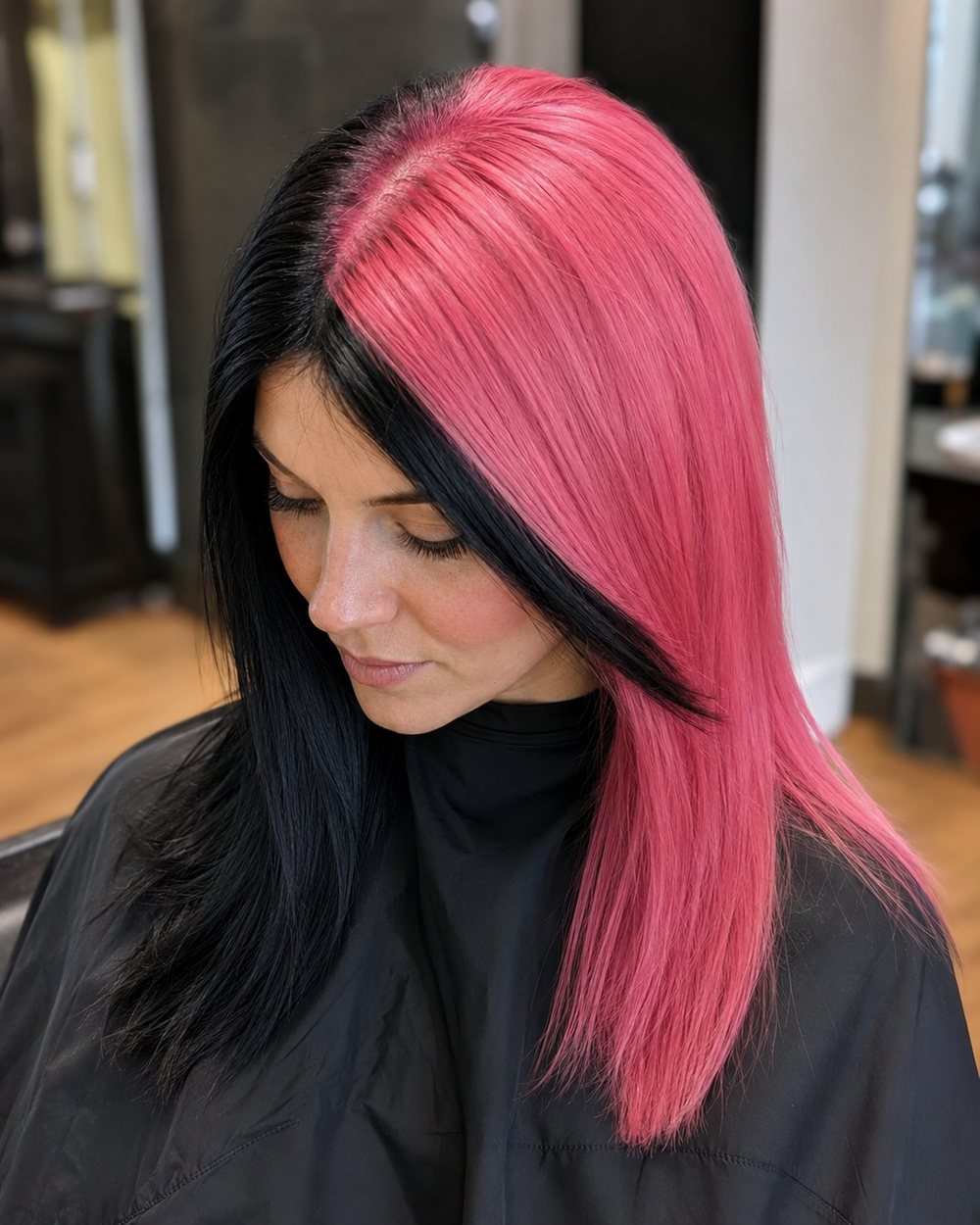 Medium-length hair divided diagonally into black and pink sections