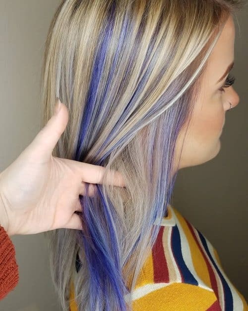 Blue and purple peekaboo highlights revealed beneath blonde hair