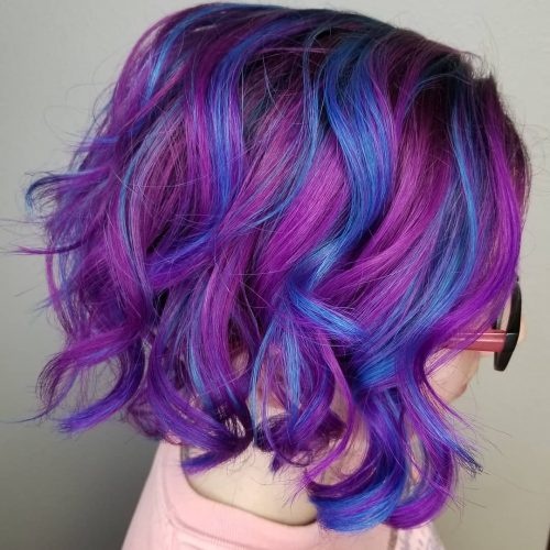 Chunky blue and purple highlights on a curled shoulder length hairstyle