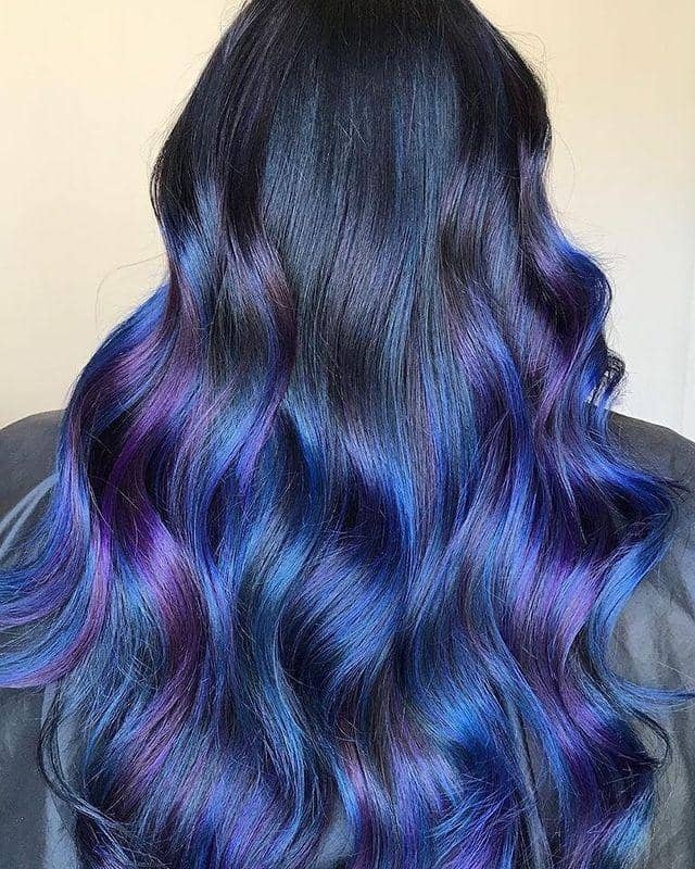 Long dark waves with midnight blue and deep purple balayage and dark roots