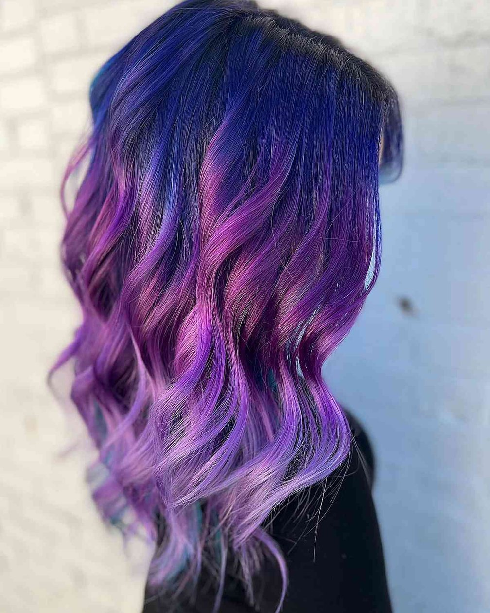 Royal blue roots blending into purple ombre on long wavy hair